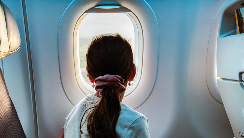 Child looking out airplane window